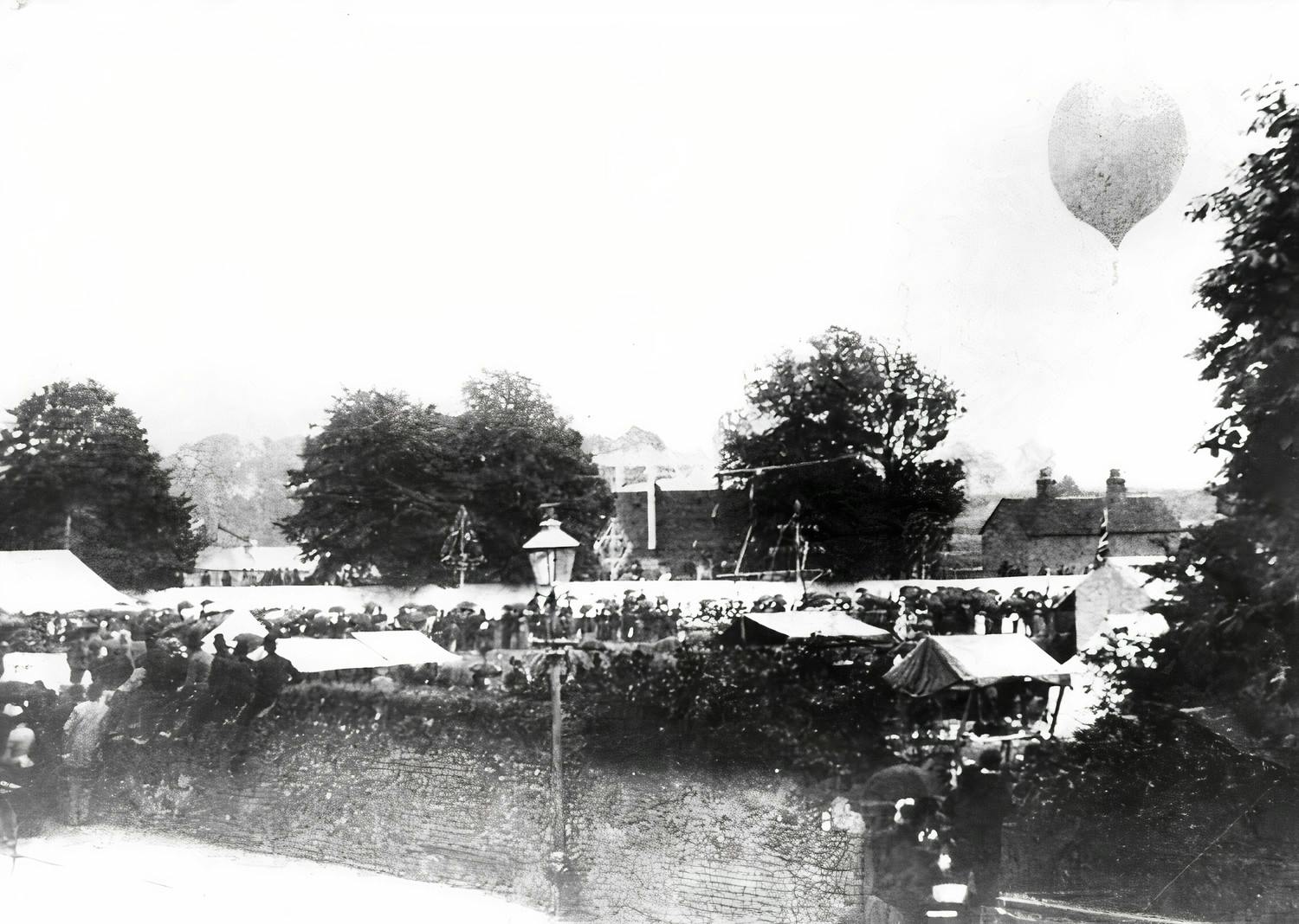 The annual ‘Sudbury Amateur Sports, Bicycle and Boat Races’ taking place on the sports field in Quay Lane and the river beyond. Here the camera has caught one of the special attractions in 1888 – the town Postmaster, Mr Hills, making a balloon ascent from the field. The balloon was filled with gas provide by the gas works just across the Lane; the balloon later landed safely at Newton Green.