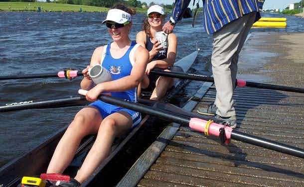 The scullers are handed their cups at the landing stage. 